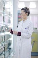 pharmacist chemist woman standing in pharmacy drugstore photo