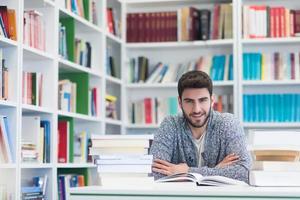 portrait of student while reading book  in school library photo