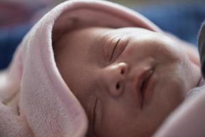 One month newborn baby sleeping  in bed photo