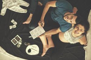 top view of couple checking a list of things for their unborn baby photo