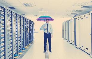 businessman hold umbrella in server room photo