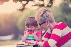 mom and her little daughter using tablet computer photo