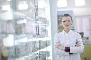 Farmacéutico químico mujer de pie en farmacia droguería foto