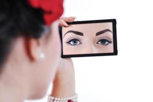 beautiful young woman applying makeup photo