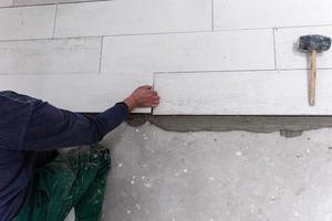 worker installing the ceramic wood effect tiles on the floor photo