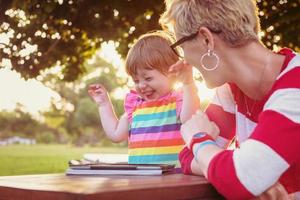 mom and her little daughter using tablet computer photo