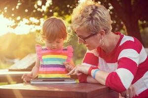 mom and her little daughter using tablet computer photo