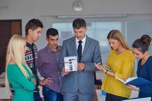 group of students working with teacher on  house model photo