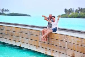 feliz pareja joven divertirse en la playa foto