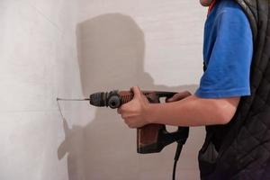 construction worker drilling holes in the bathroom photo