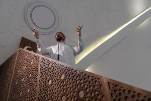 Muslims young arabic Imam has a speech on friday afternoon prayer in mosque. photo