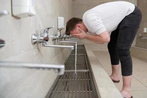 A Muslim takes ablution for prayer. Islamic religious rite photo