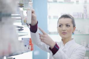 pharmacist chemist woman standing in pharmacy drugstore photo