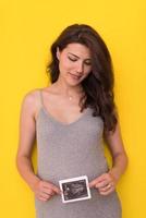 mujer embarazada mostrando imagen de ultrasonido foto