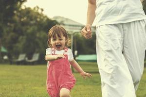 mother and little daughter playing at backyard photo