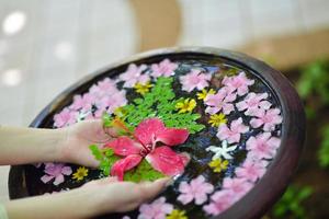 mano femenina y flor en agua foto