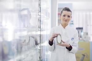 Farmacéutico químico mujer de pie en farmacia droguería foto