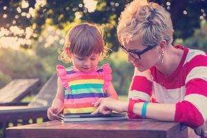 mom and her little daughter using tablet computer photo