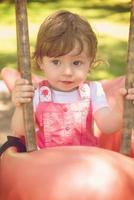 little girl swinging  on a playground photo