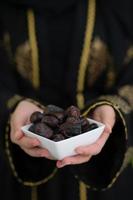 modern muslim woman holding a plate of dates in ramadan kareem photo