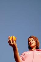 beautyful girl throwing orange in air photo