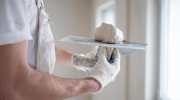 construction worker plastering on gypsum walls photo