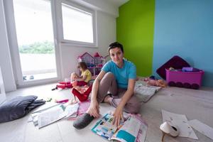 mother and her cute llittle daughter enjoying free time on the floor at home photo