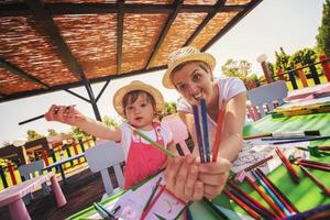 mamá y su pequeña hija dibujando imágenes coloridas foto