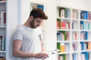 student in school library using tablet for research photo