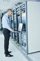 young it engineer in datacenter server room photo