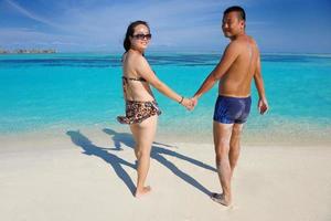 feliz pareja joven disfrutando del verano en la playa foto