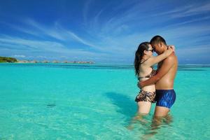 asian couple enjoying summer on beach photo