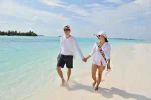 feliz pareja joven divertirse en la playa foto