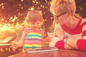 mom and her little daughter using tablet computer photo