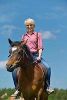 mujer feliz montar a caballo foto