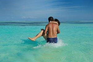 asian couple enjoying summer on beach photo