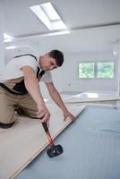 Professional Worker Installing New Laminated Wooden Floor photo