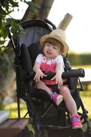 baby girl sitting in the baby stroller photo