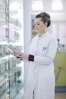 pharmacist chemist woman standing in pharmacy drugstore photo