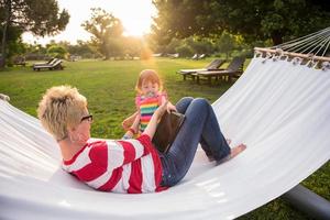 mom and a little daughter relaxing in a hammock photo