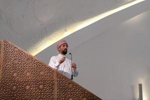Muslims young arabic Imam has a speech on friday afternoon prayer in mosque. photo