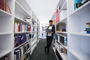 estudiante con tableta en la biblioteca foto