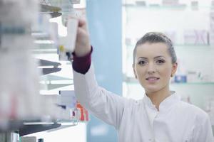 Farmacéutico químico mujer de pie en farmacia droguería foto