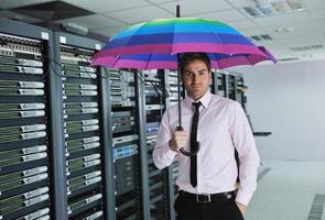 businessman hold umbrella in server room photo