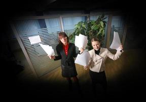 two businesswoman throw papers in office photo