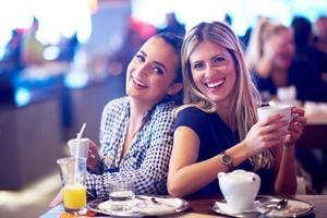 las chicas toman una taza de café en el restaurante foto