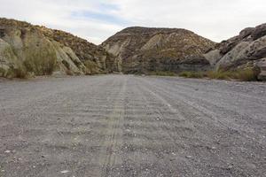 straight dirt road in the desert photo