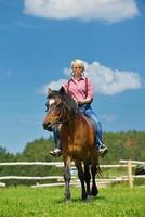 mujer feliz montar a caballo foto