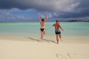 happy young couple have fun on beach photo