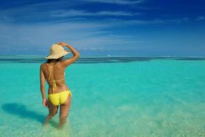 hermosa mujer relajarse en la playa tropical foto